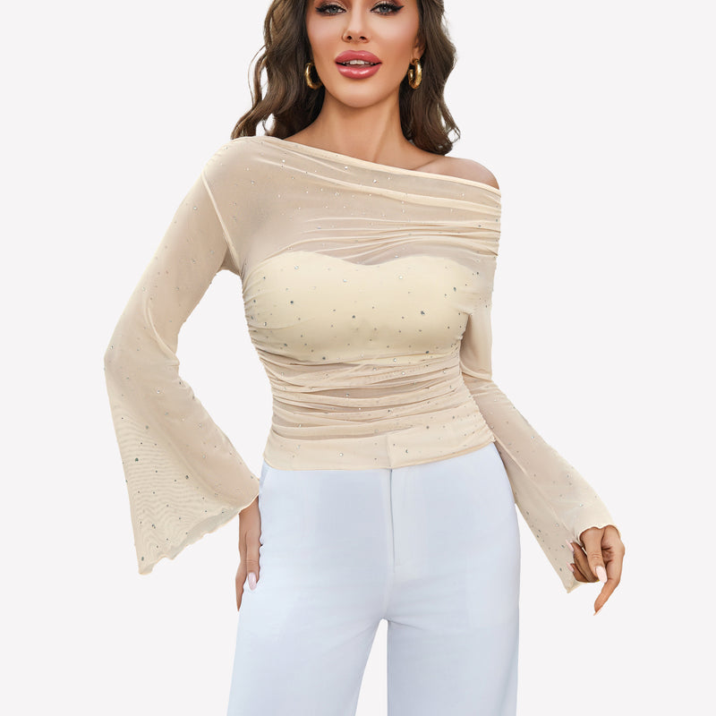 Beige mesh off-shoulder top with rhinestone accents, long bell sleeves, and white pants