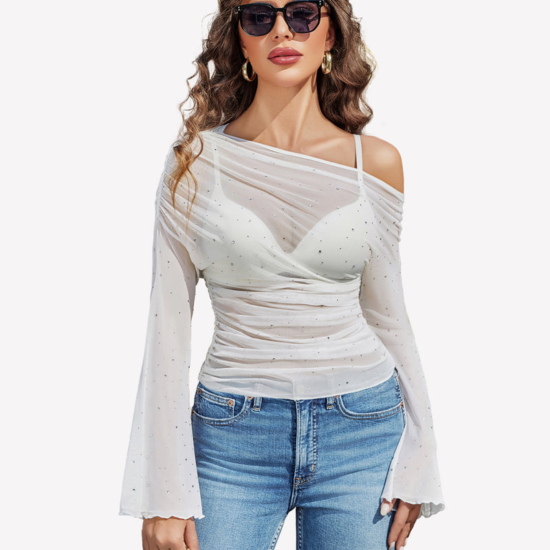 White mesh off-shoulder top with rhinestone accents, bell sleeves, and jeans, a stylish look.