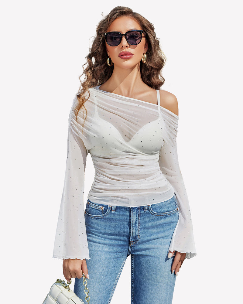 White mesh off-shoulder top with rhinestone accents, bell sleeves, and jeans, a stylish look.