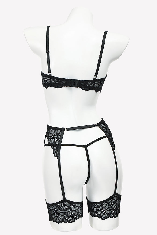 Black lace lingerie set on mannequin: lace bra, garter belt, thong, and thigh straps