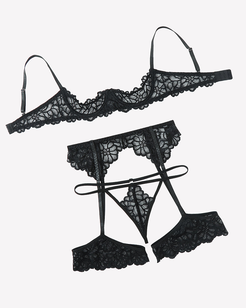 Black lace lingerie set flat lay: lace bra top, thong, garter belt, and thigh straps