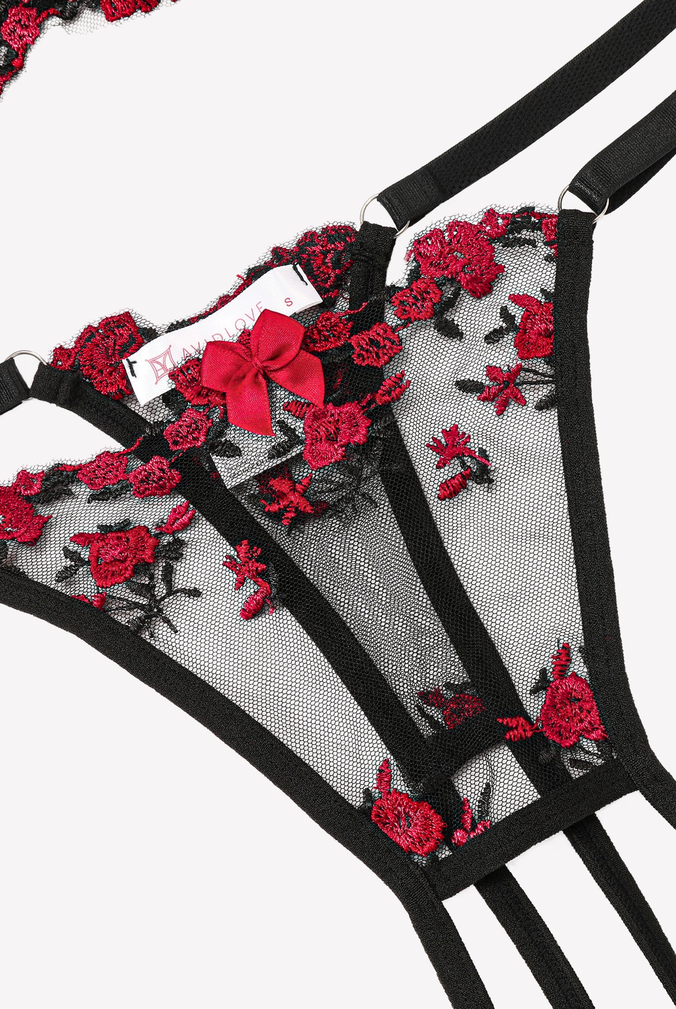 Sheer lace underwire bra with black straps and red floral embroidery, close-up