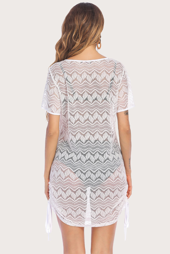 White lace beach cover-up with leaf pattern and drawstring detail. Ideal for swimwear and beachwear.