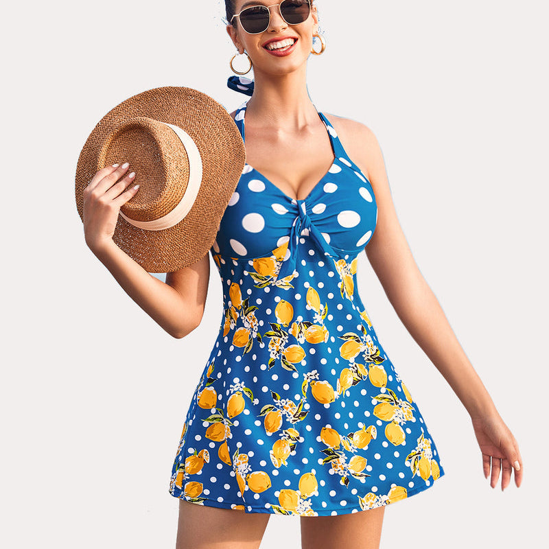Lemon print halter tankini swimsuit with boyshorts. Blue polka dot pattern, smiling woman.