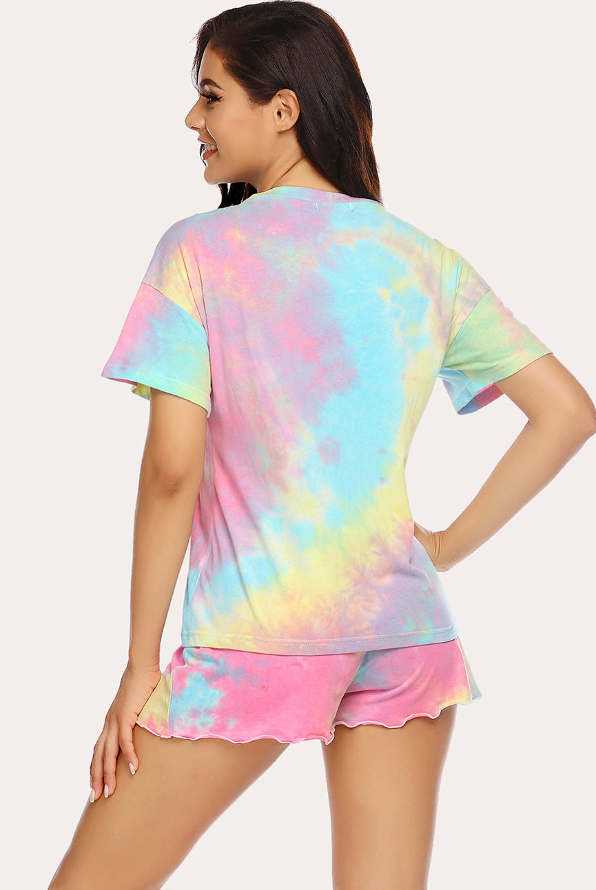 Tie-dye pajama set back view: short-sleeve button top and ruffled shorts, pastel