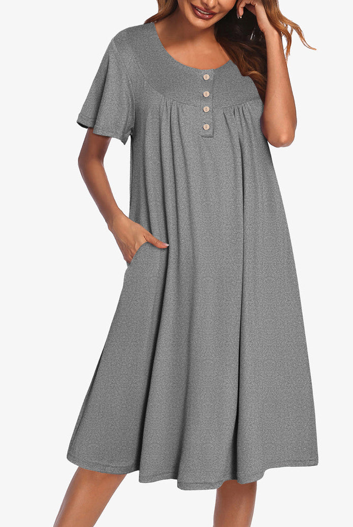 Women’s short sleeve grey henley dress with button placket and gathered yoke.