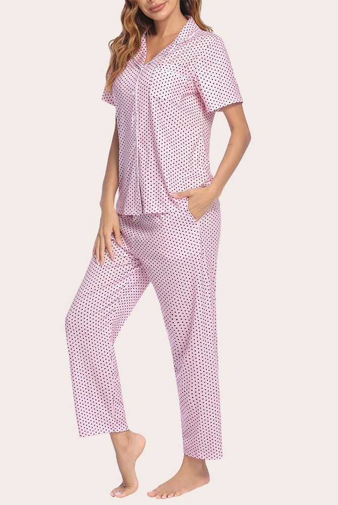 Pink polka dot notch collar short sleeve pajama set with button-down top and long pants.