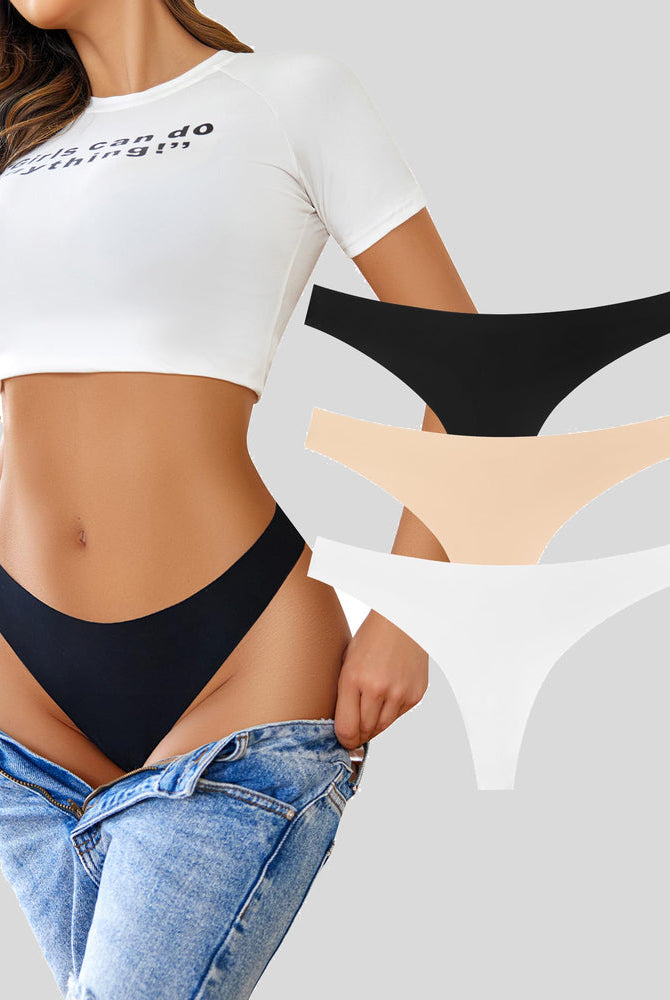 Seamless thongs, black, nude, and white. No-show, breathable. Model in "Girls can do anything!" top.