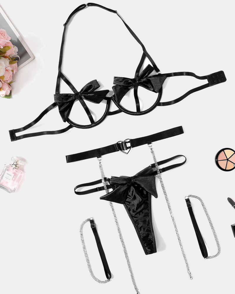 Black bow lingerie set with underwire bra, garter belt, chain detail, and satin accents