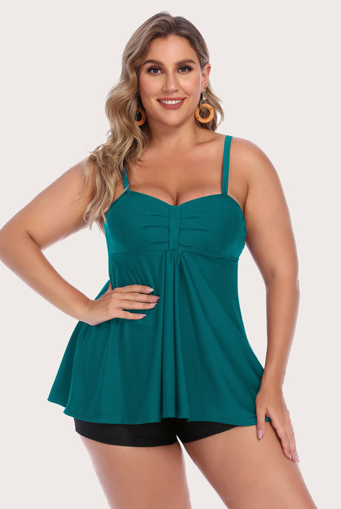 Plus-size teal tankini swimsuit with shorts, adjustable straps, and sun-protective fabric.