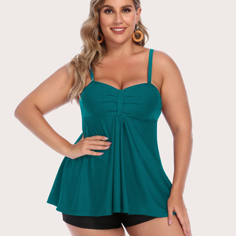 Plus-size teal tankini swimsuit with shorts, adjustable straps, and sun-protective fabric.