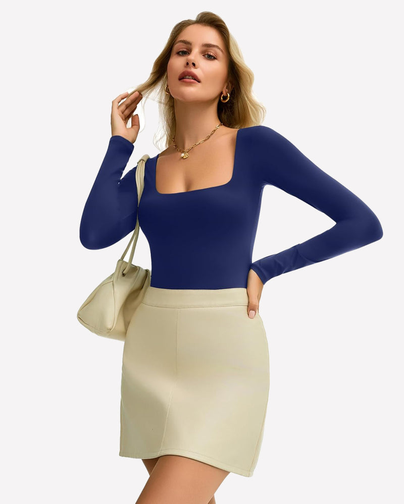 Navy blue square neck bodysuit, ultra-stretchy, shows off bodyline, paired with a cream skirt.