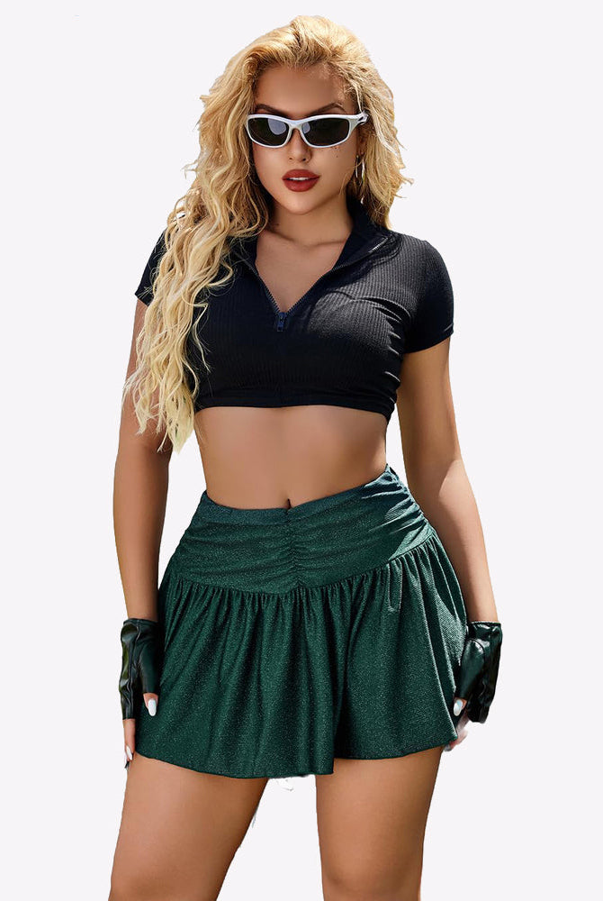 Green glitter A-line mini skirt with ruffle hem, paired with black crop top, confident look.