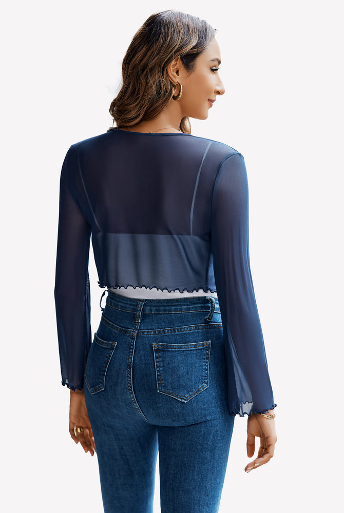 Navy blue sheer mesh shrug top with bell sleeves and tie front, paired with jeans