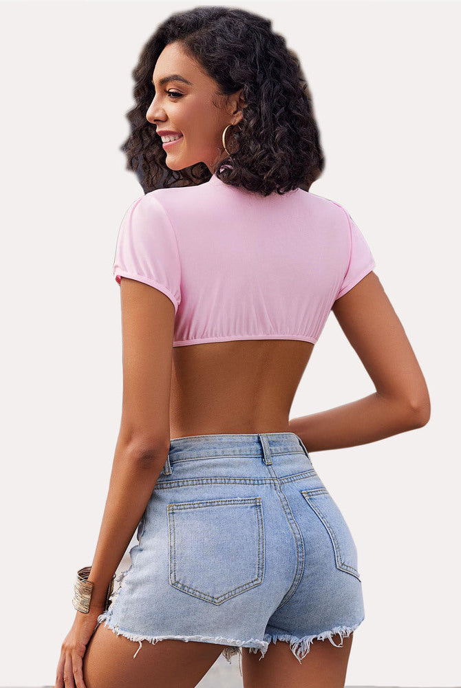 Pink short sleeve crop top with open back, worn with denim shorts, ideal for cosplay or daily wear.