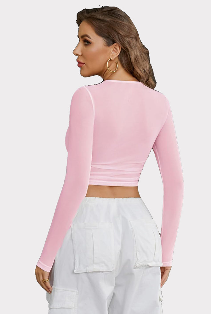 Pink sheer mesh crop top with long sleeves and keyhole detail, perfect for parties.