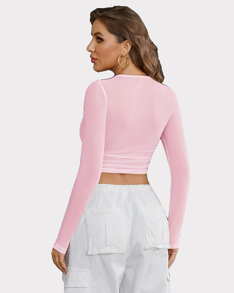 Pink sheer mesh crop top with long sleeves and keyhole detail, perfect for parties.