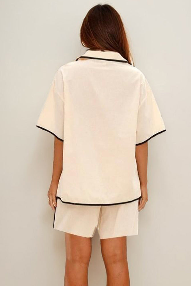 Beige linen pajama set showing back of lace-up shirt and shorts.