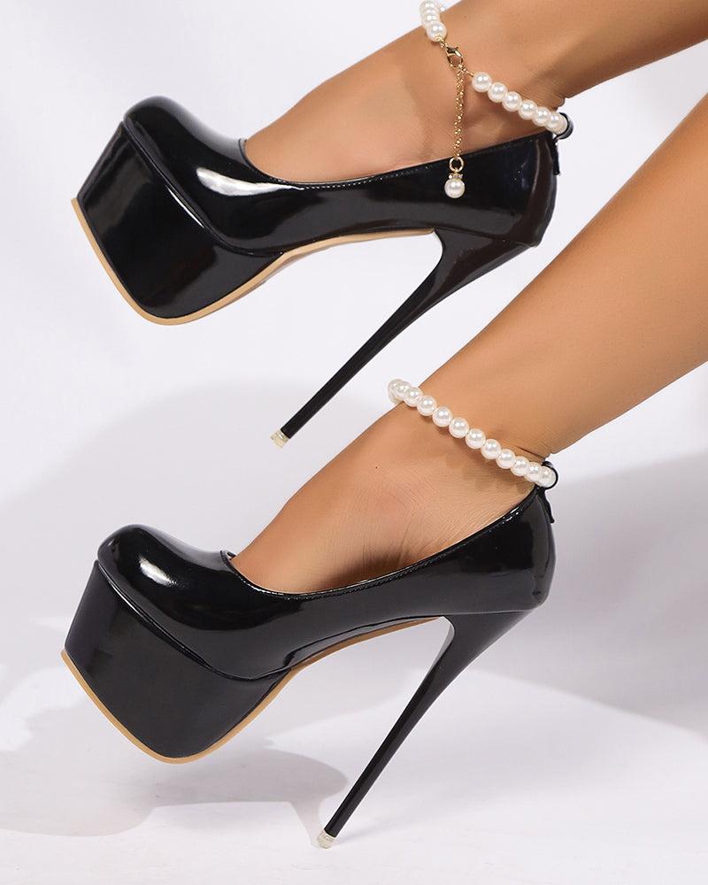Black patent platform pumps with pearl anklet chain detail and gold-trim sole