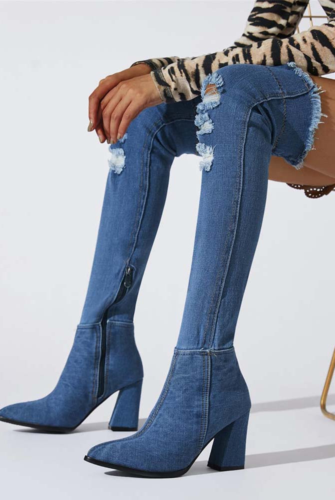 Distressed over-the-knee stiletto boots in blue denim, pointed toe, tall block heel, side zip.