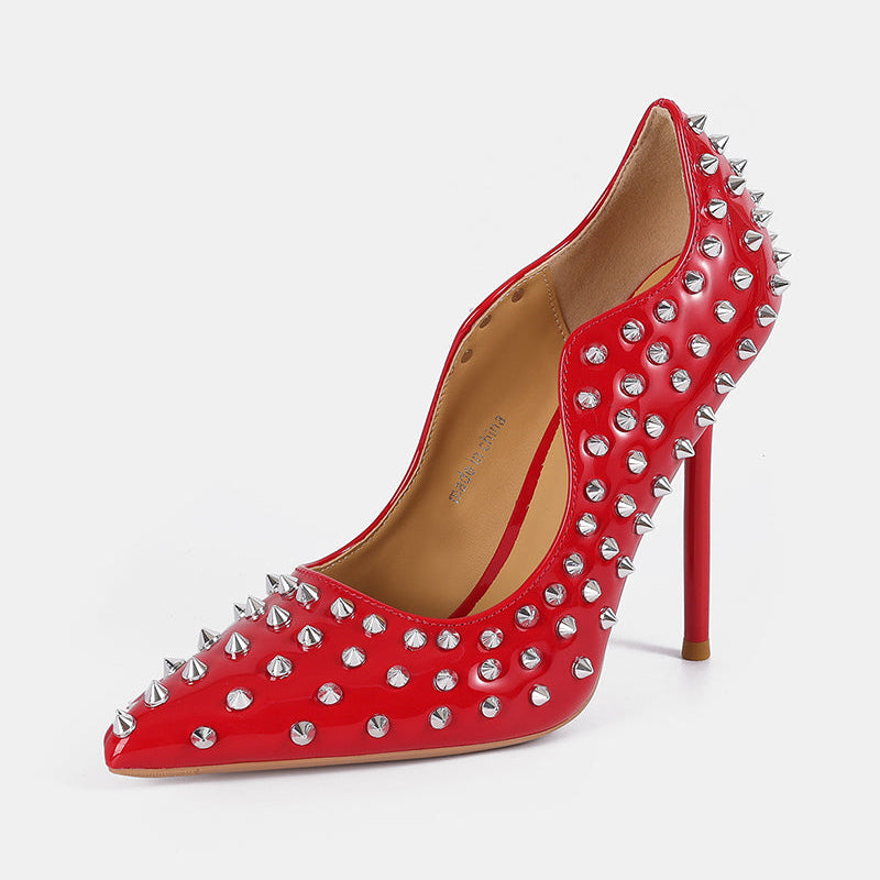Red patent pointed-toe stiletto pump with silver spike studs and high heel