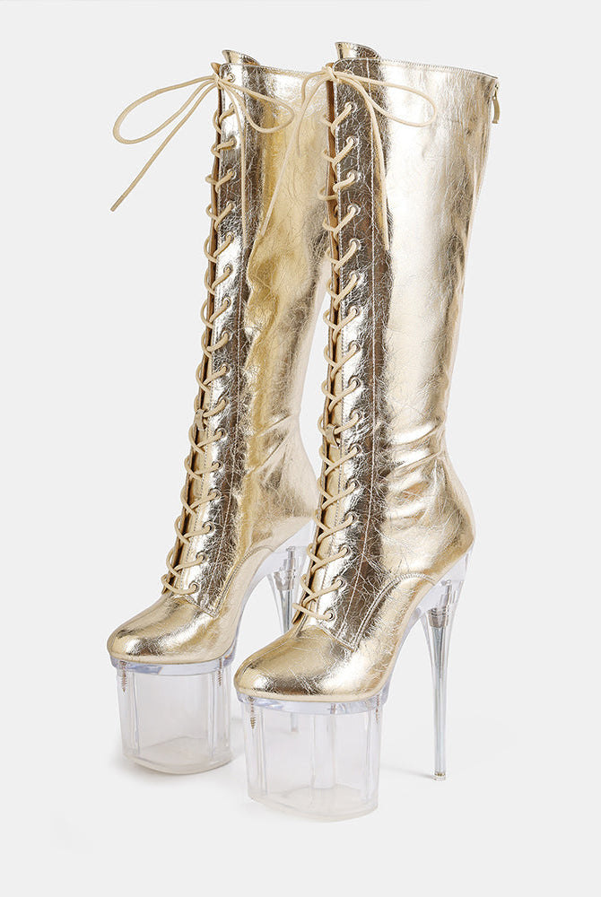 Gold metallic knee-high lace-up stiletto boots with clear platform heels, front view