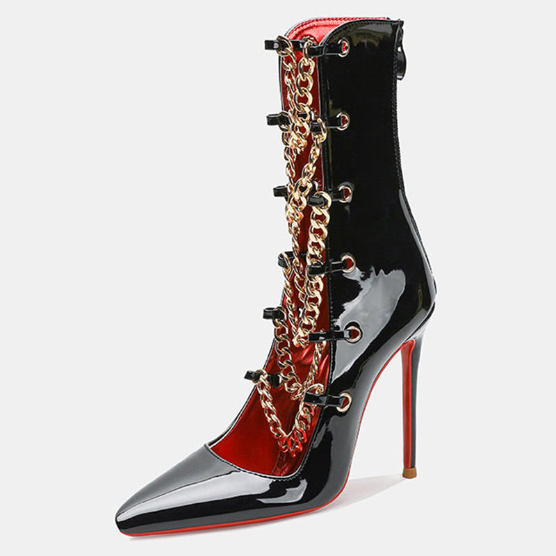 Black patent stiletto ankle boot with gold chain detail and contrast red lining.