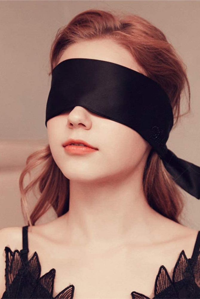 Black satin eye mask, perfect for meditation or romantic use. Adjustable, comfortable design.
