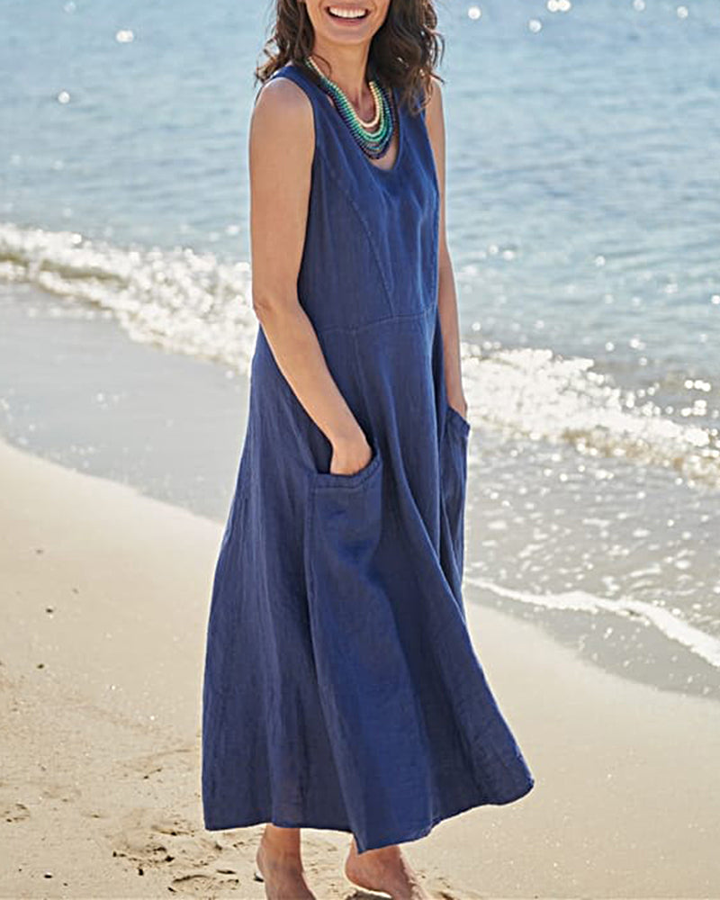 Sleeveless blue linen dress with pockets, perfect for vacation, on a woman at the beach