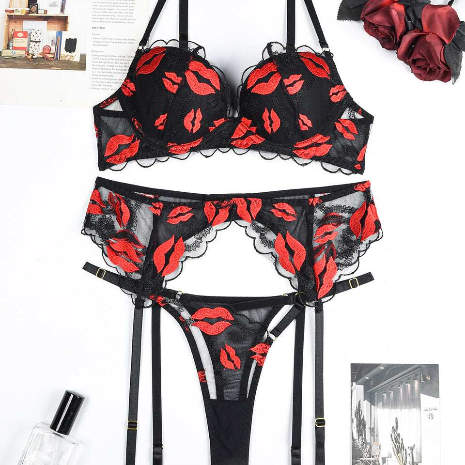 Black lace lingerie set with red lip embroidery. Bra, garter belt, and thong. Sensual design.