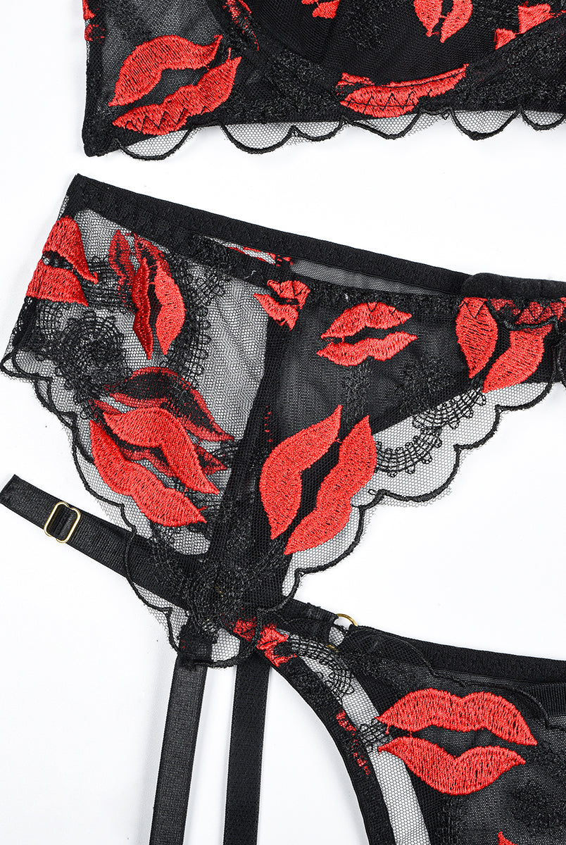 Black lace lingerie set with red lip embroidery; bra, garter belt, and thong with adjustable straps