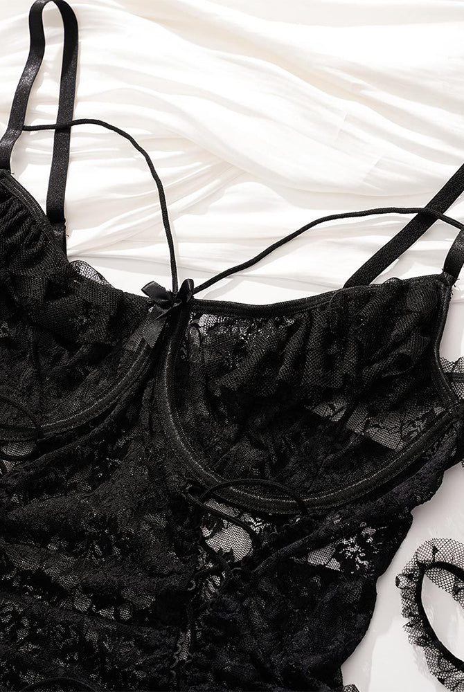 Black plus size lace bodysuit with floral lace, adjustable straps, and lace-up detail