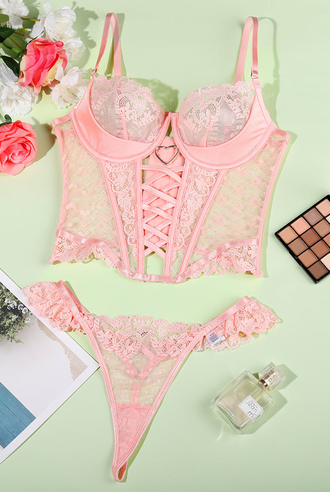 Pink lace heart corset and matching lace thong set, flat lay view