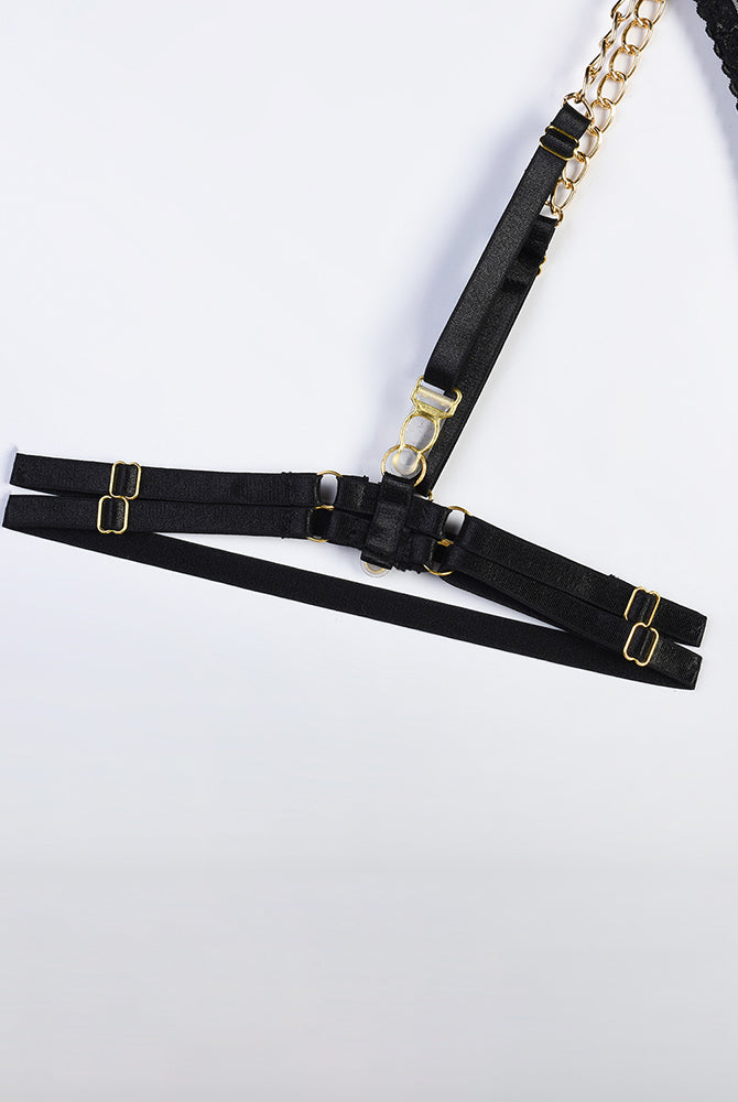Black harness lingerie set with gold chain, adjustable straps, and floral lace details.