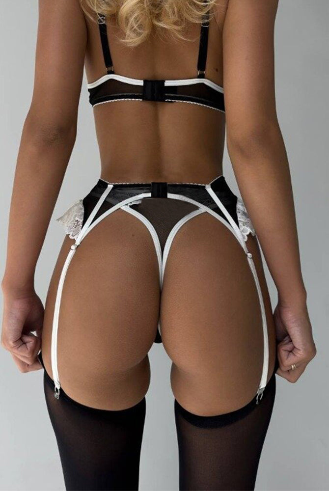 Black and white lace lingerie set with garter belt and push-up bra. Sexy lingerie for women.