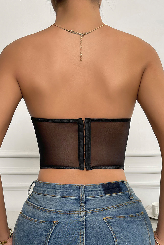 Black strapless mesh bustier top with boning, offering support and shaping, paired with jeans.