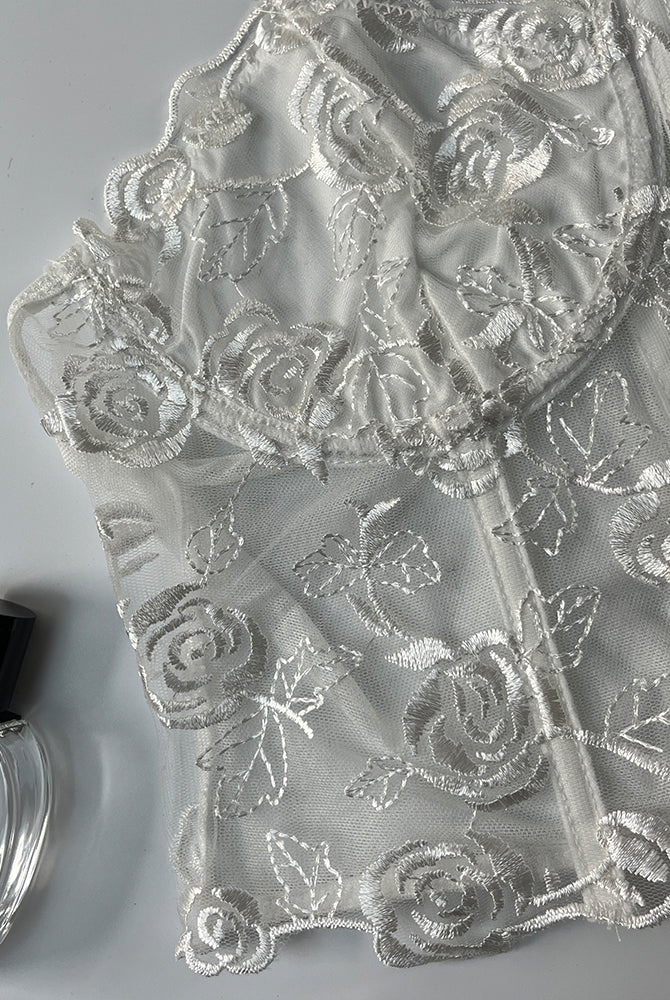 White floral strapless mesh bustier with rose embroidery and boning for elegant support.