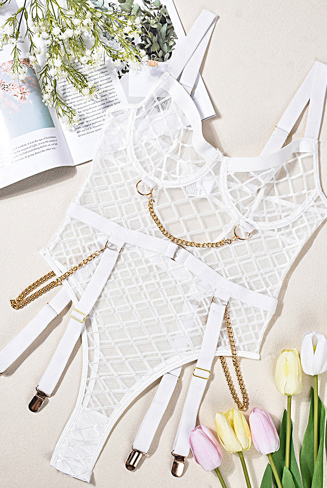 White mesh chain bodysuit on flat lay with gold-tone chains and garter straps
