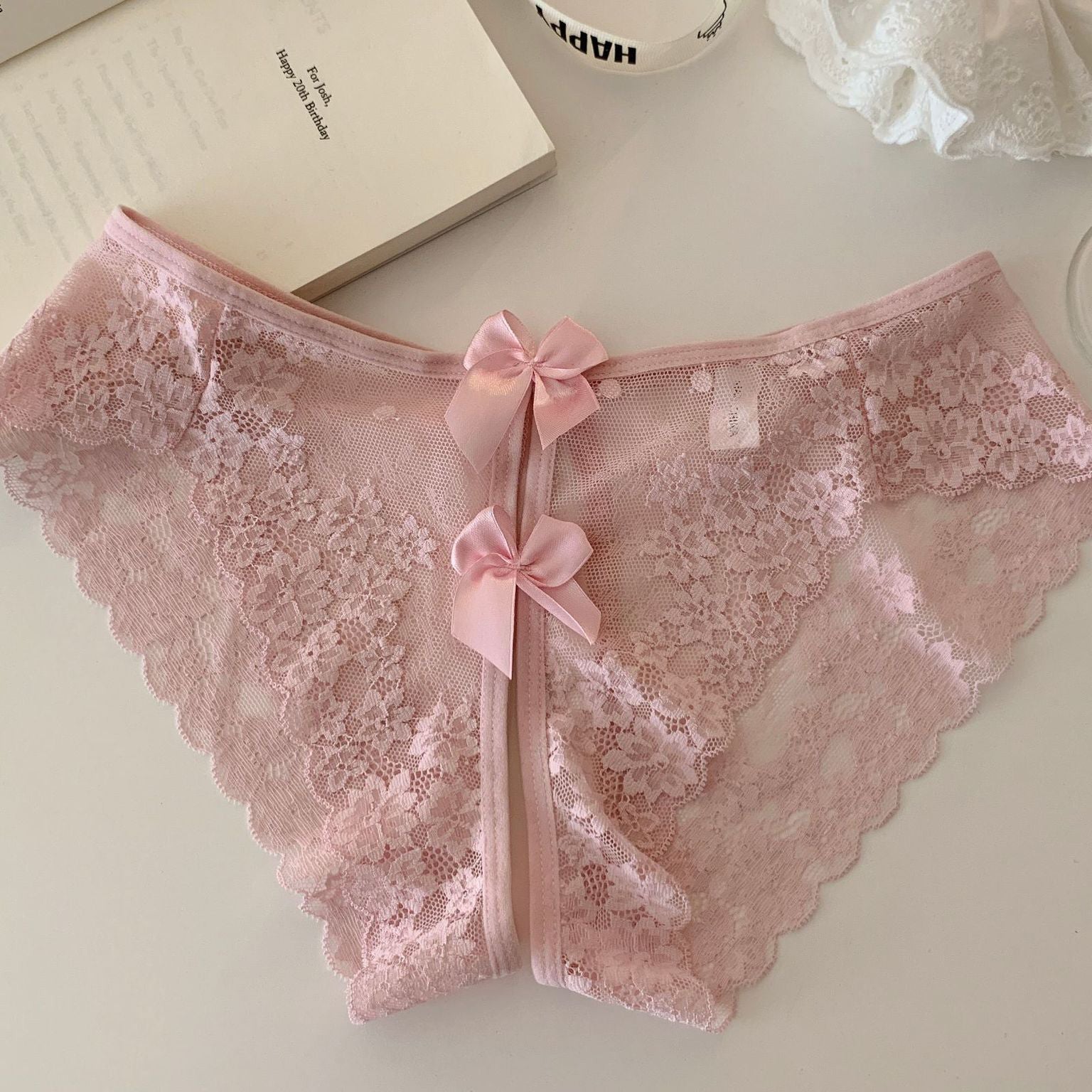 Light pink sheer floral lace panties with scalloped edges and double bow-back ties