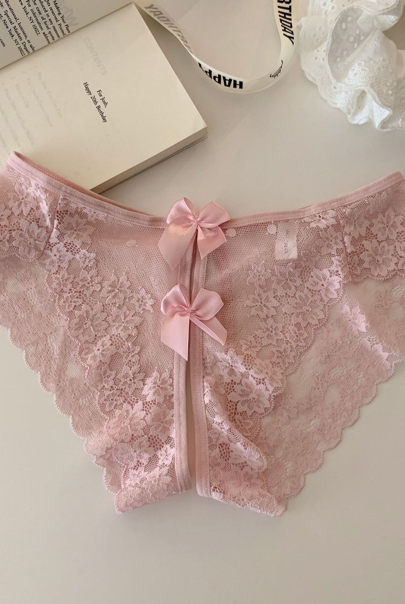 Light pink sheer floral lace panties with scalloped edges and double bow-back ties