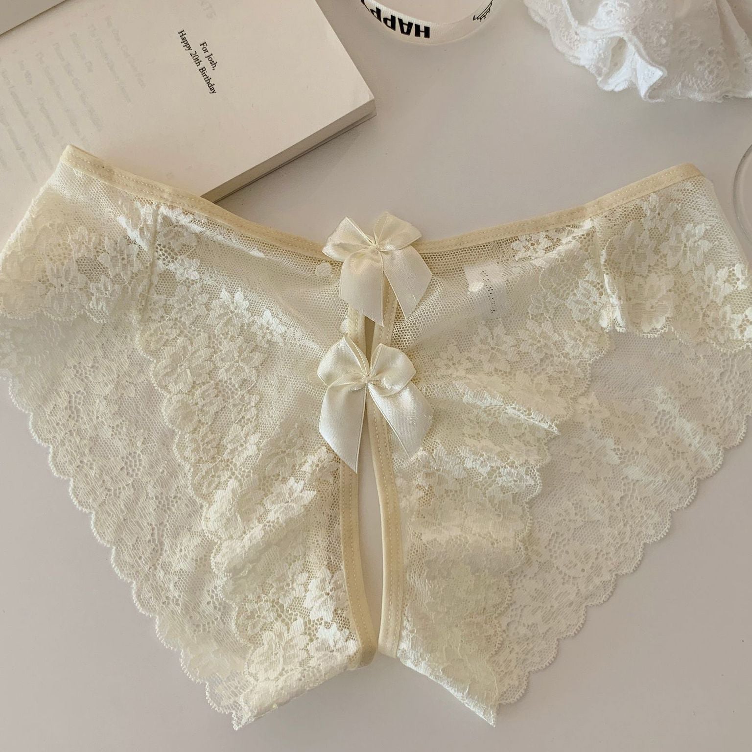Cream sheer floral lace panties with scalloped edges and center back ribbon bow