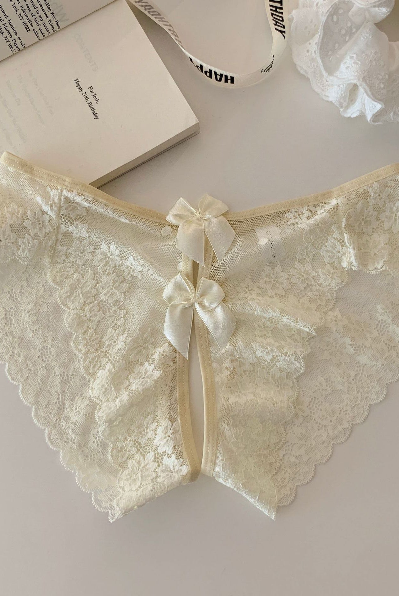Cream sheer floral lace panties with scalloped edges and center back ribbon bow