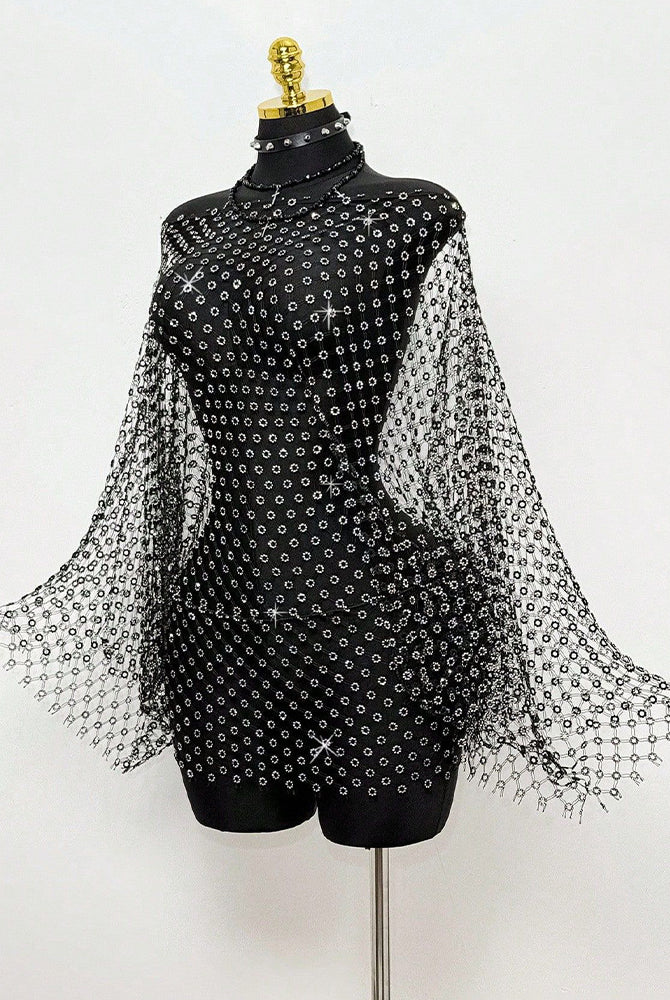 Black rhinestone mesh cape top on mannequin with long flowing sleeves and sparkly trim