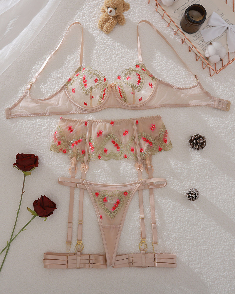 Flat lay: floral embroidered underwire bra, panties, and garter set in nude mesh