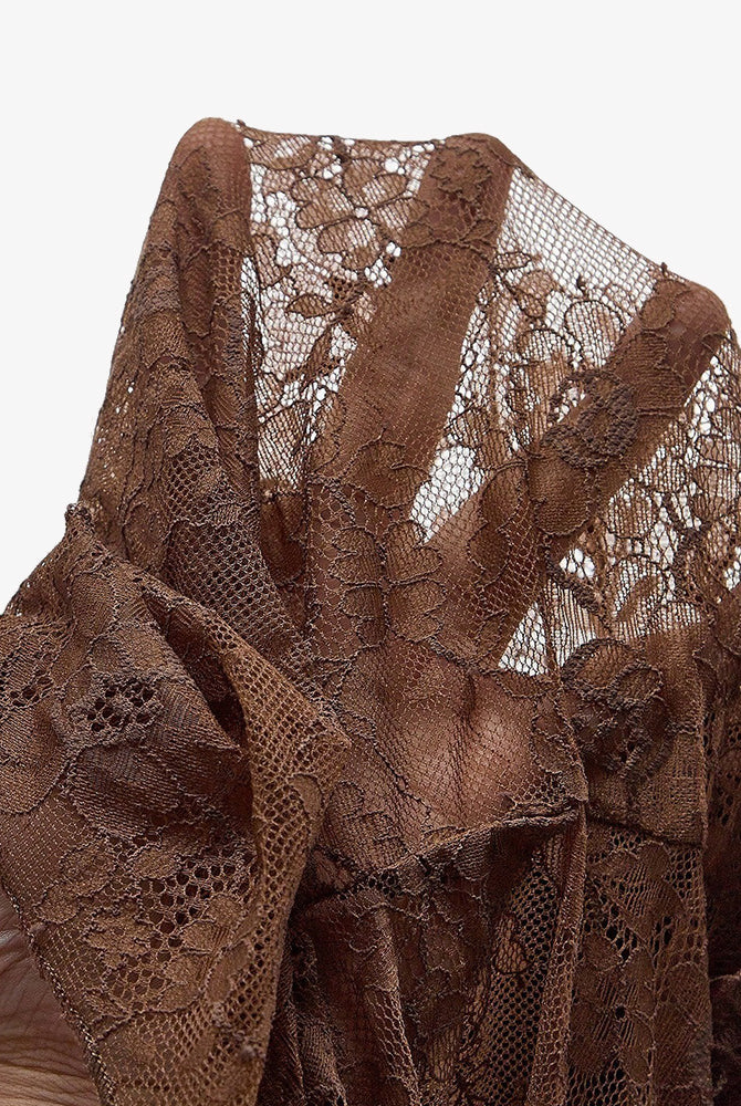 Brown lace bodysuit fabric close-up with ruffled tutu trim