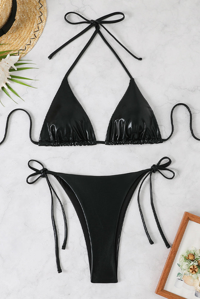 Black shiny metallic triangle halter bikini top and matching side-tie thong bottoms, laid flat