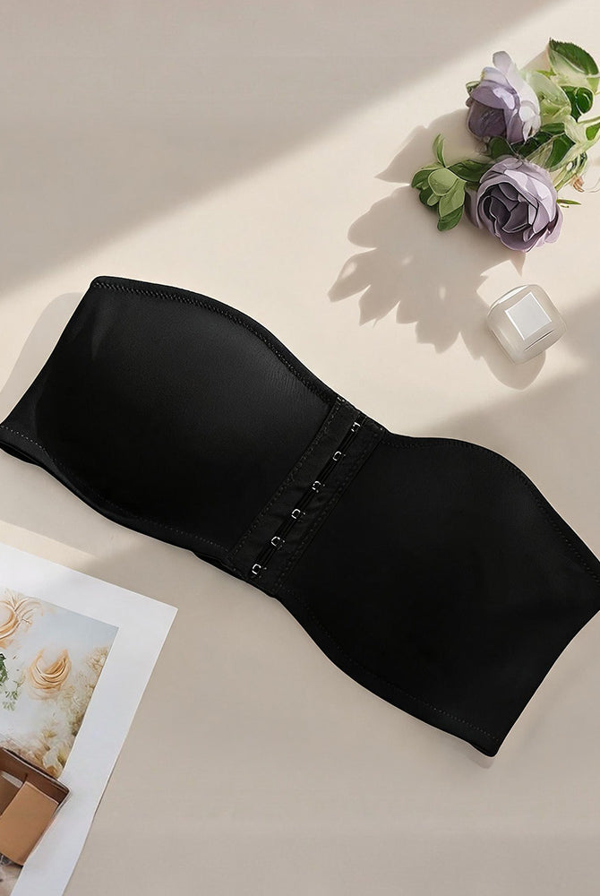 Strapless bandeau bra in black, flat lay showing smooth cups and front hook closure