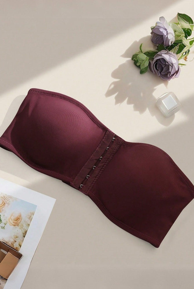 Strapless bandeau bra in burgundy, flat lay showing smooth cups and front hook closure