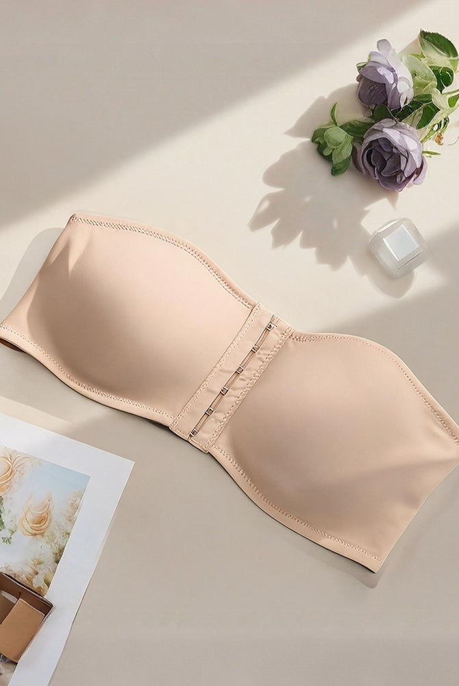 Strapless bandeau bra in beige, flat lay showing smooth cups and front hook closure