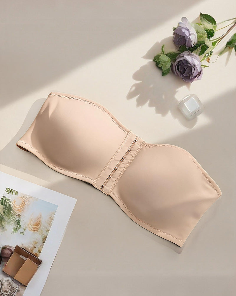 Strapless bandeau bra in beige, flat lay showing smooth cups and front hook closure